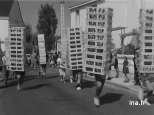 photographie d'archive de l'ina de personnes portant des cagettes