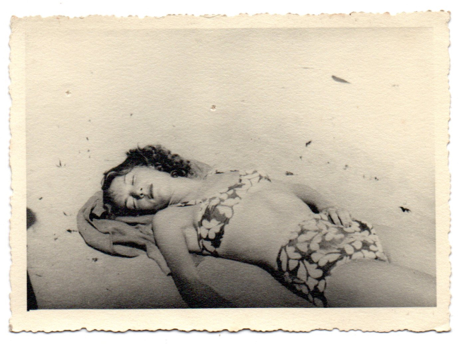 ancienne photographie d'une jeune femme allongé sur la plage en maillot de bain